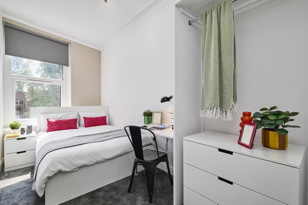 A bright and inviting bedroom featuring a large...