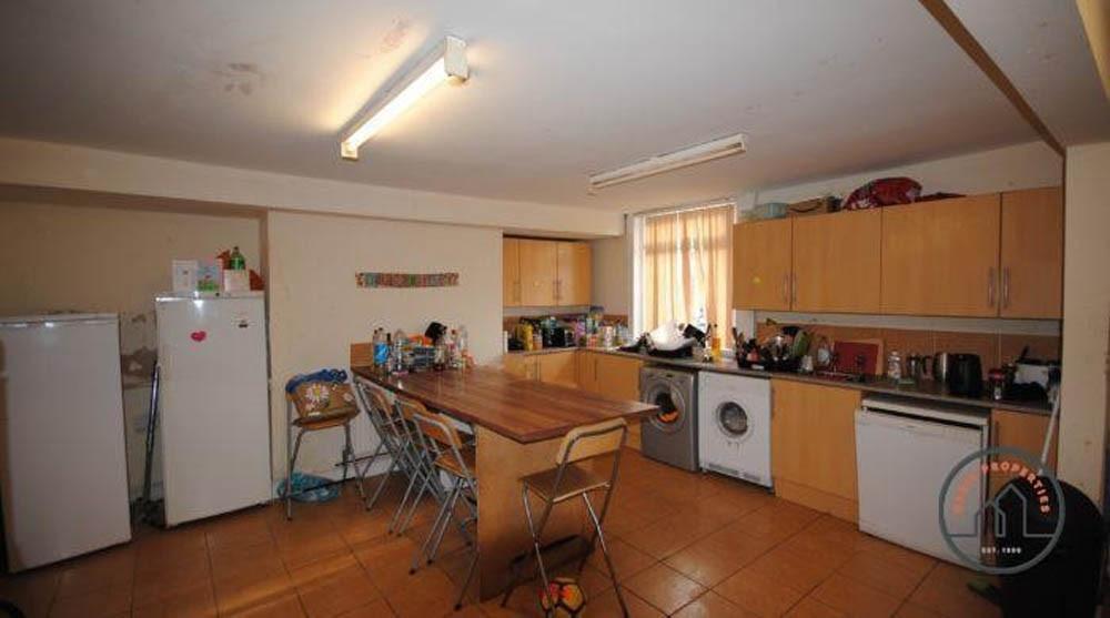 A well-lit, spacious kitchen area with wooden c...