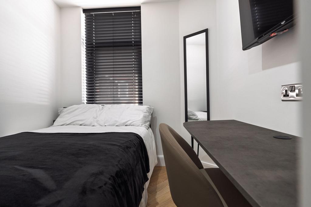 A modern, well-lit bedroom featuring a large wi...