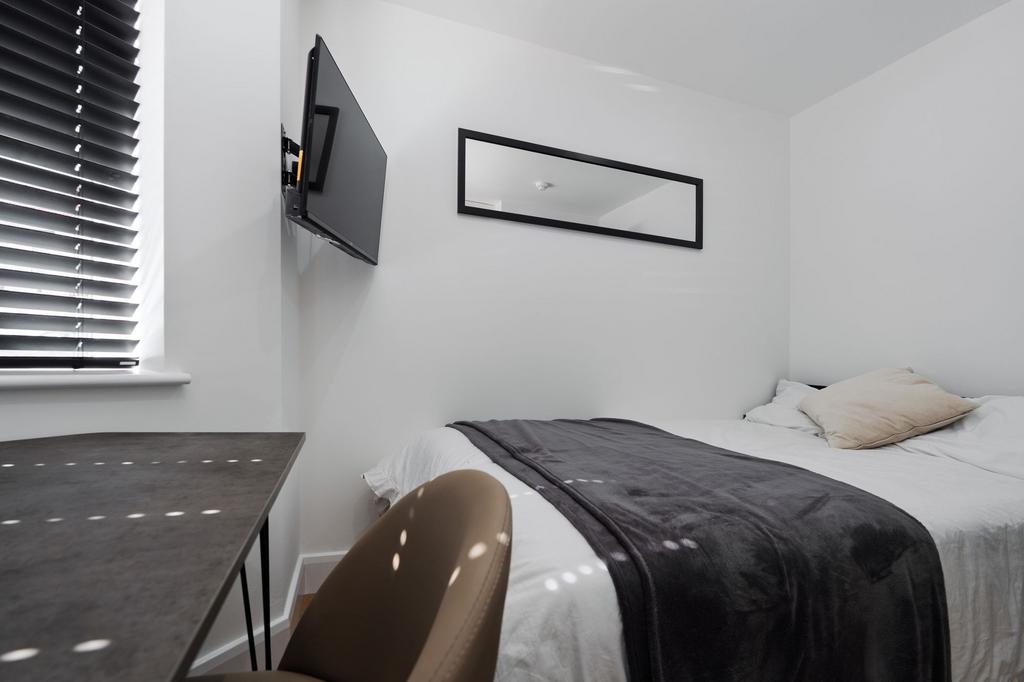 A bright and minimalist master bedroom with a c...