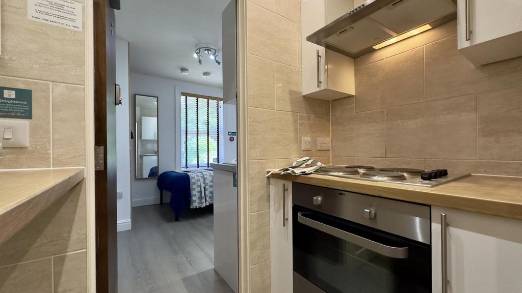 A modern and tidy kitchenette with ample natura...