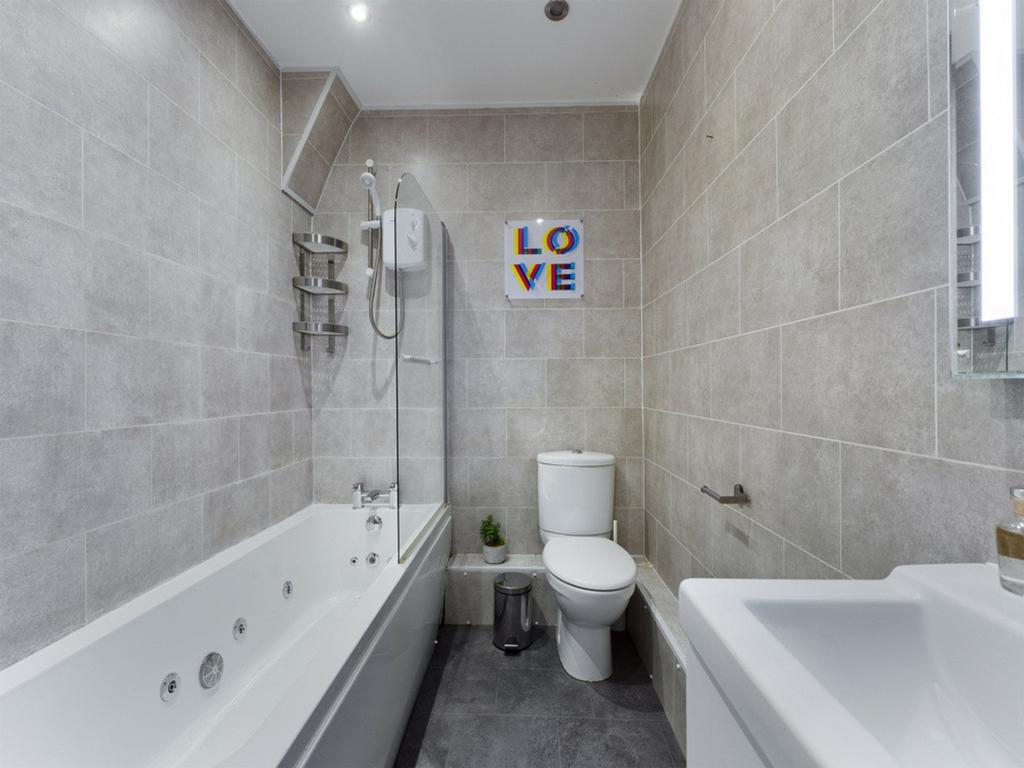 A spacious and modern bathroom featuring a styl...