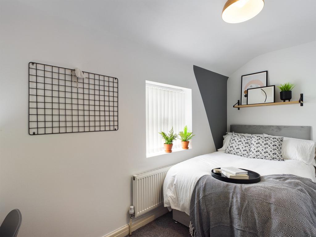 A bright and inviting double bedroom featuring ...