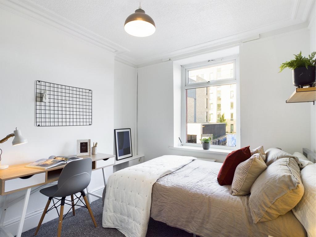A bright and inviting double bedroom with a coz...