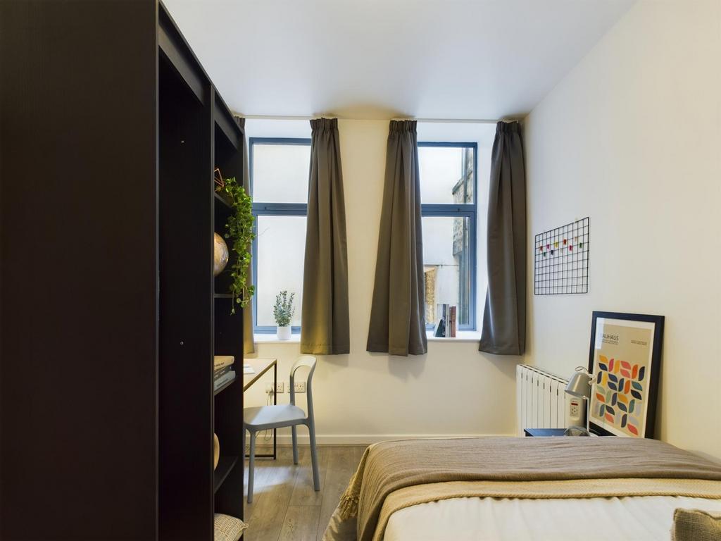 A bright and inviting double bedroom with styli...