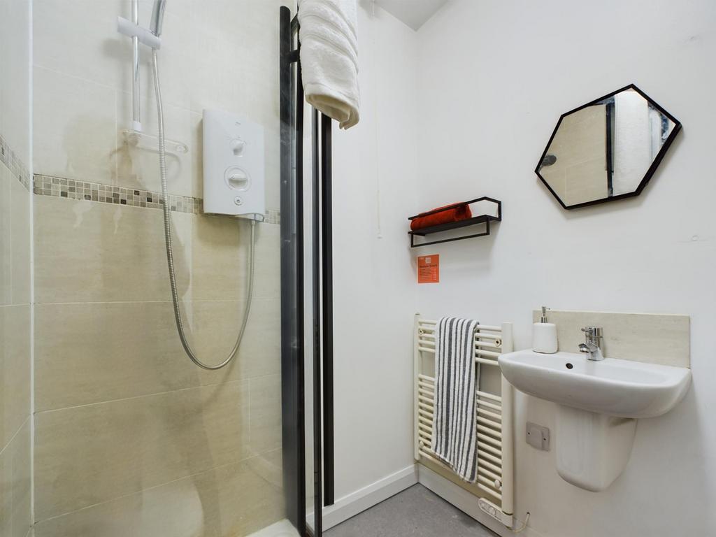 A modern and tidy bathroom featuring a shower a...