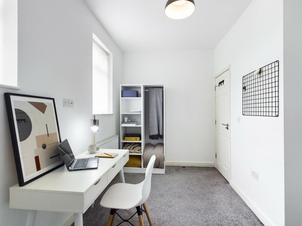 A tidy and well-lit study area featuring a desk...