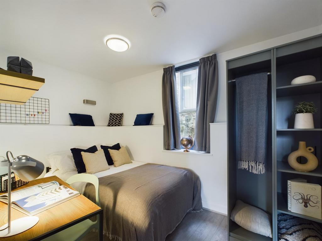 A bright and tidy double bedroom featuring styl...