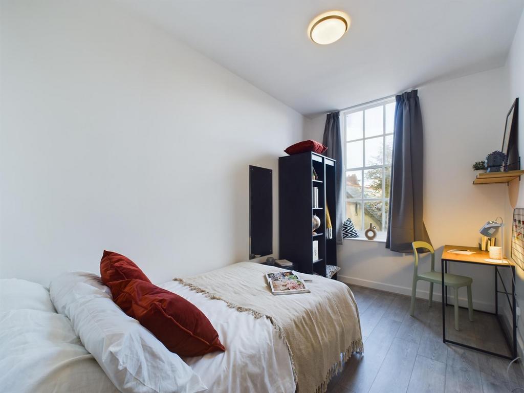 A bright and inviting double bedroom with a coz...