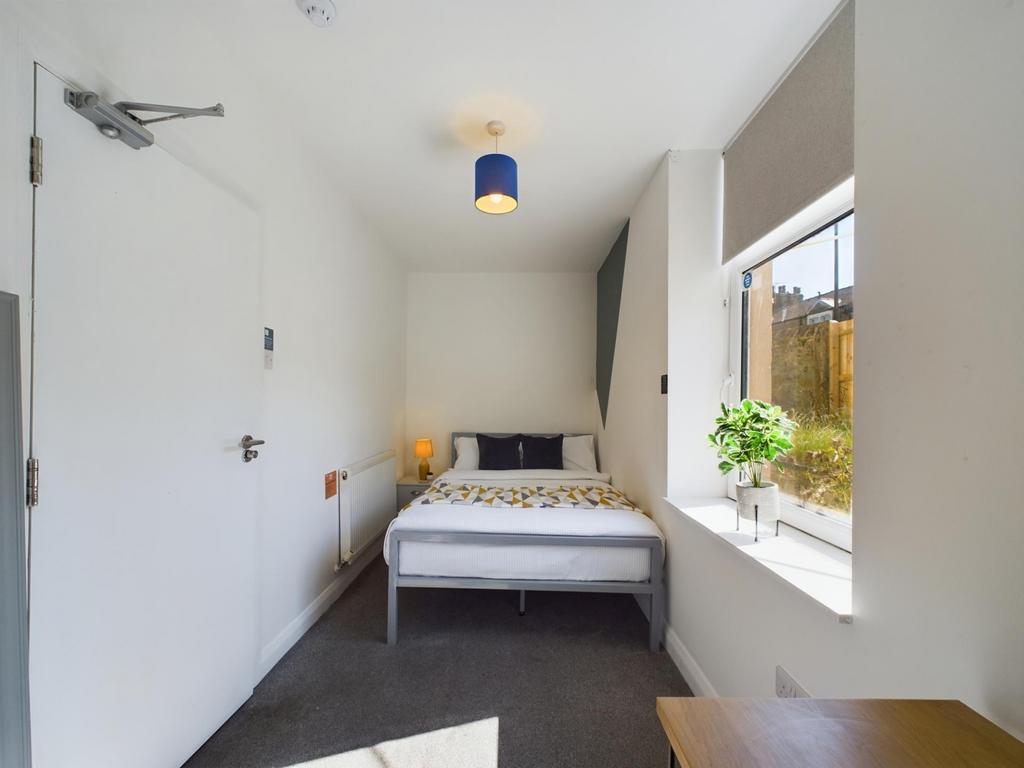 A bright and tidy bedroom featuring a comfortab...