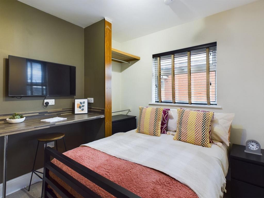 A cozy and inviting double bedroom featuring mo...