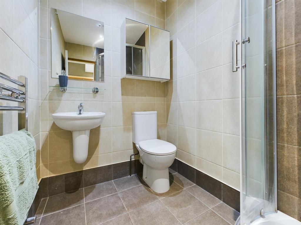 A modern and tidy bathroom featuring a shower a...
