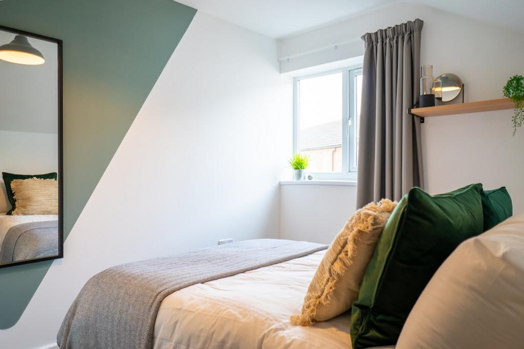 A bright and inviting double bedroom with styli...