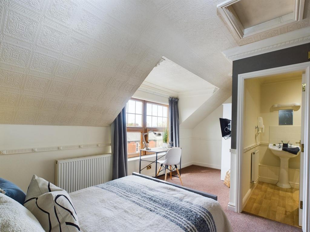 A cozy and bright double bedroom featuring a co...