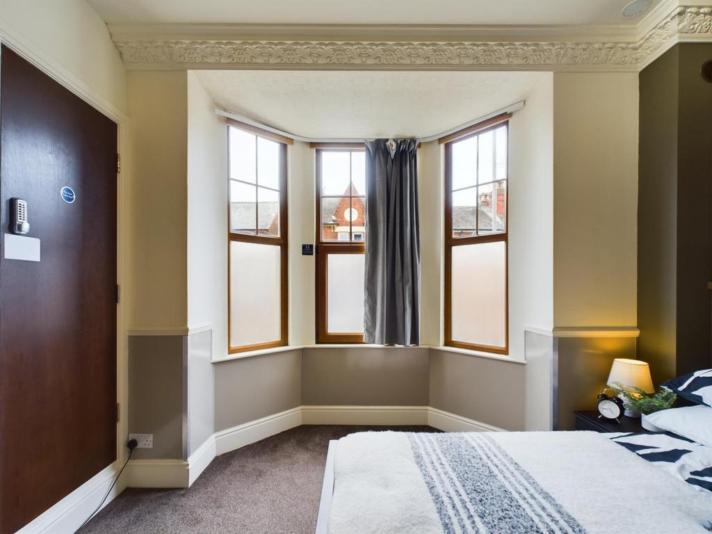 A bright and inviting double bedroom with large...