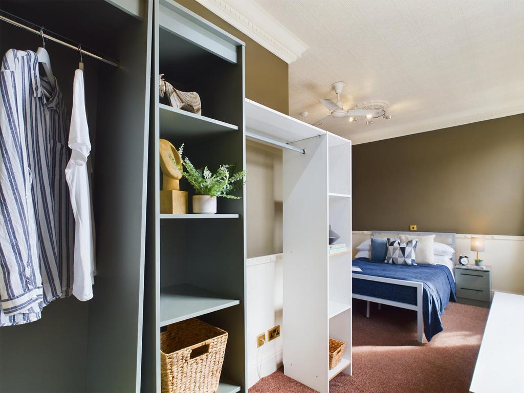 A spacious and tidy double bedroom featuring st...