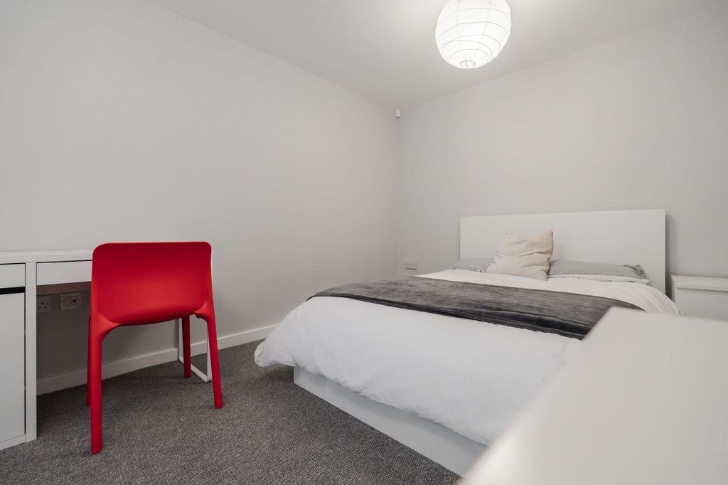 A bright and clean bedroom featuring a spacious...