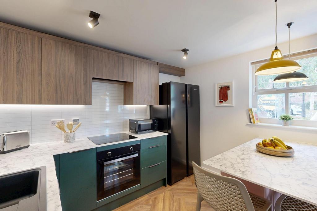 Modern and well-lit kitchen featuring sleek cab...