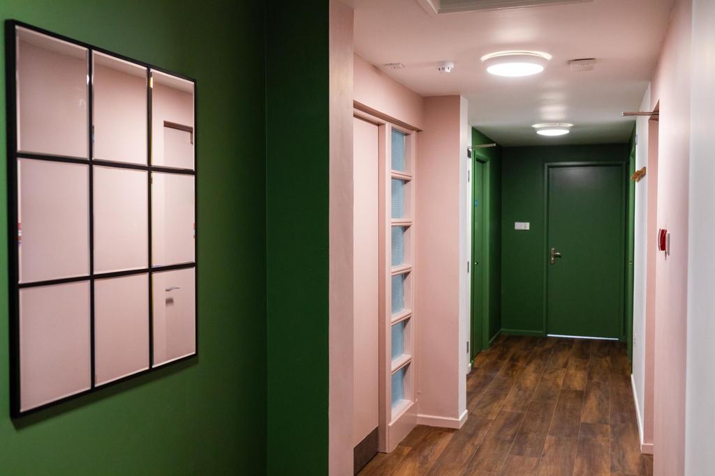 Well-lit communal hallway with modern green-pai...