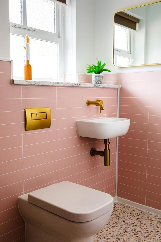 Bright, modern bathroom with pastel pink tiles,...