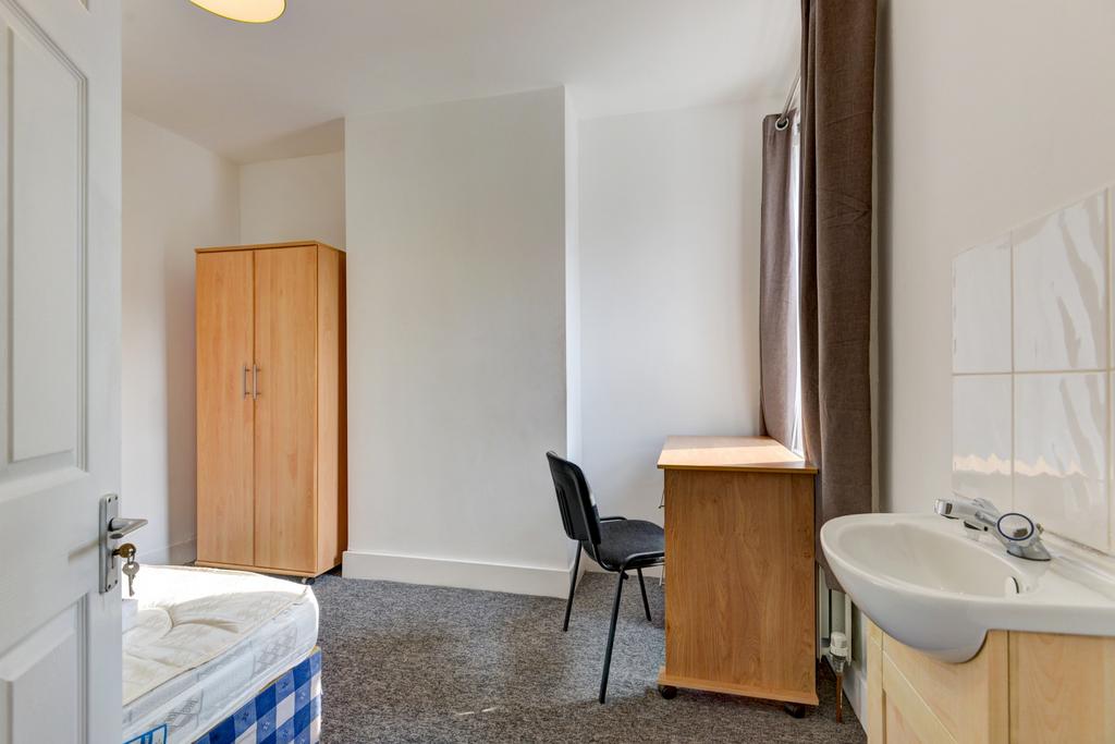 A compact bathroom with a basic sink and toilet...