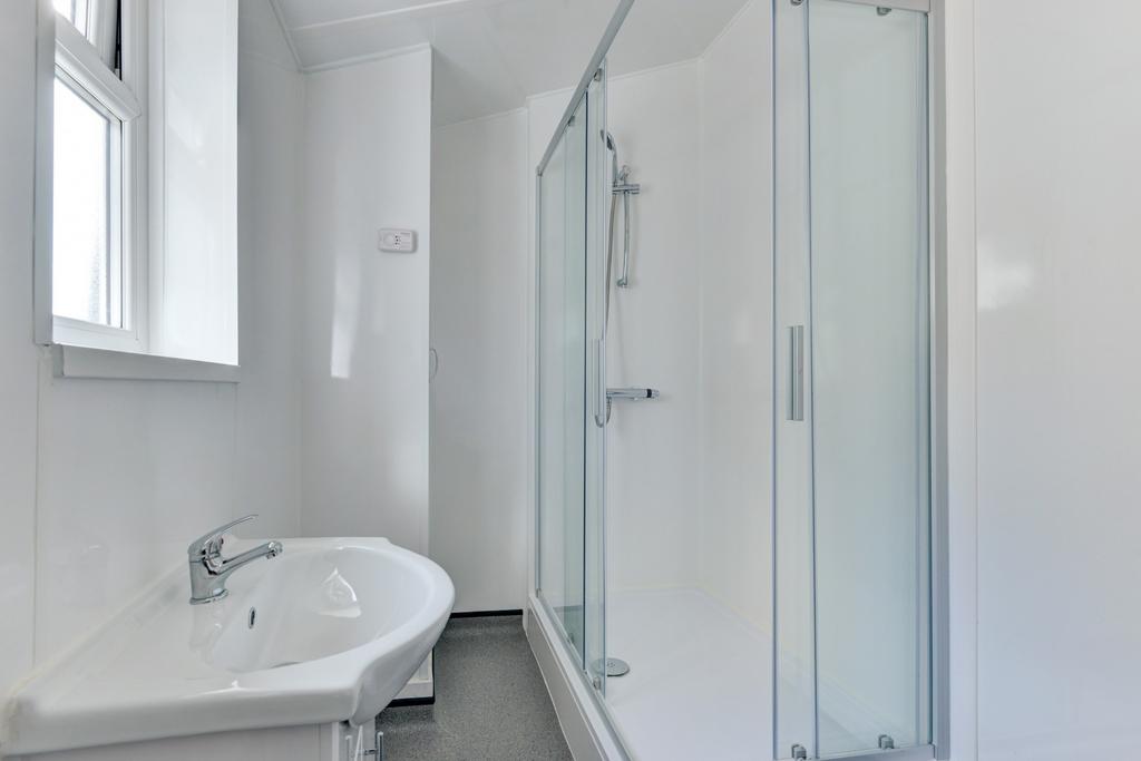 A modern, clean bathroom featuring a spacious s...