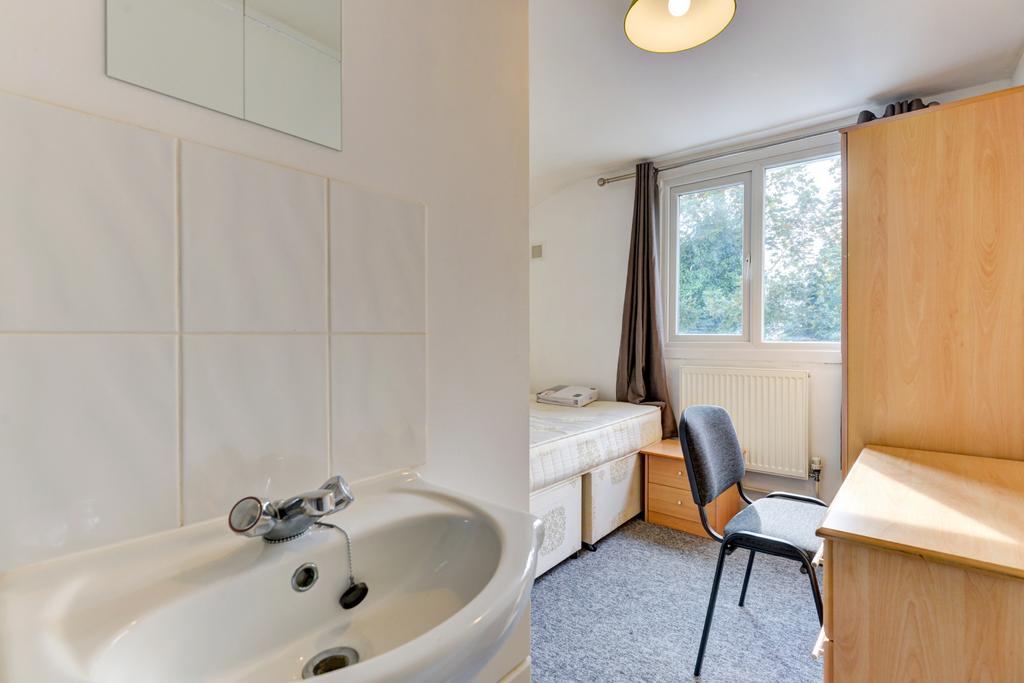 A clean, bright bathroom with a sink, tiled wal...