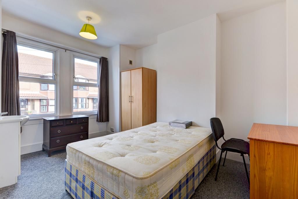 A modest single bedroom with a large window pro...