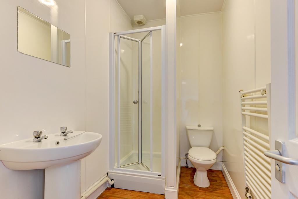 A clean and bright bathroom with a toilet, a sh...