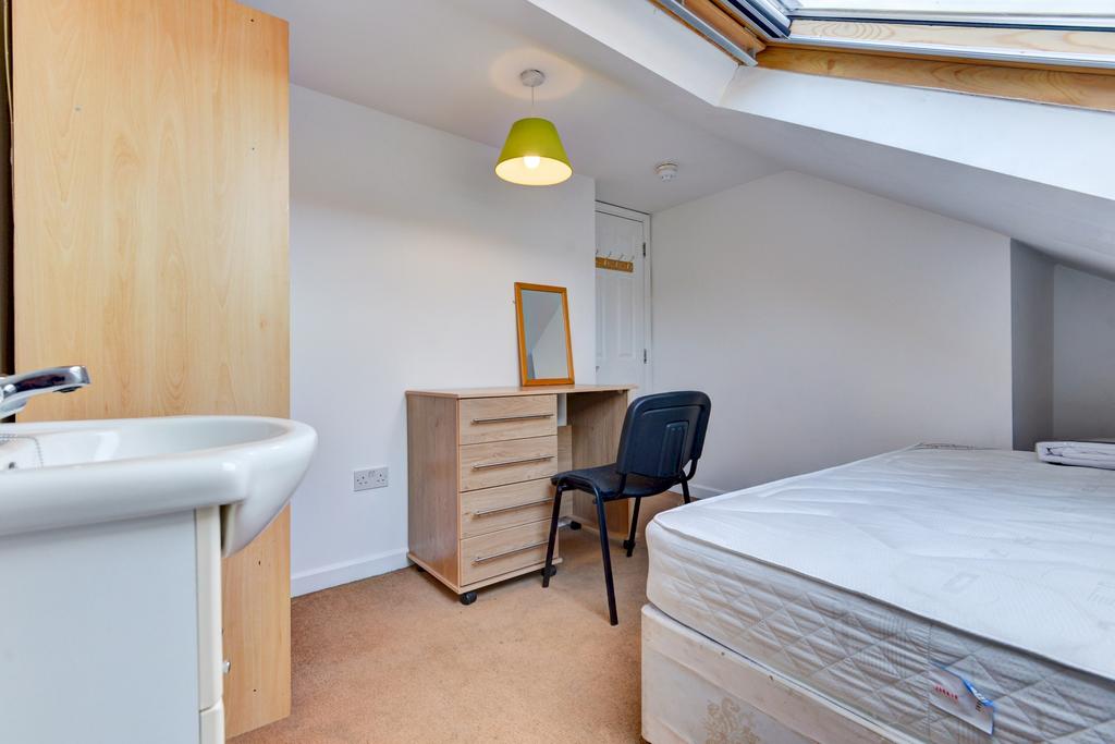 A bright and tidy bedroom featuring a comfortab...