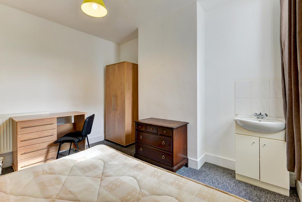 A bright and tidy bedroom featuring a comfortab...