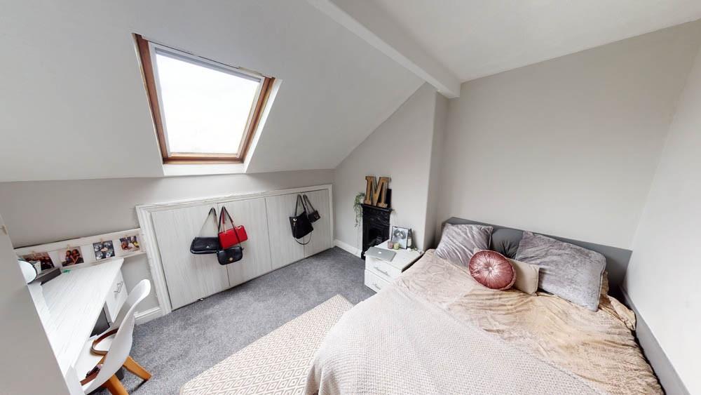 A bright, spacious master bedroom with a cozy b...