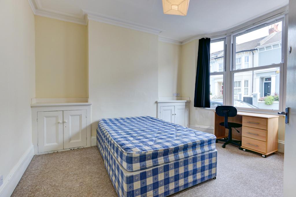A bright single bedroom featuring a comfortable...