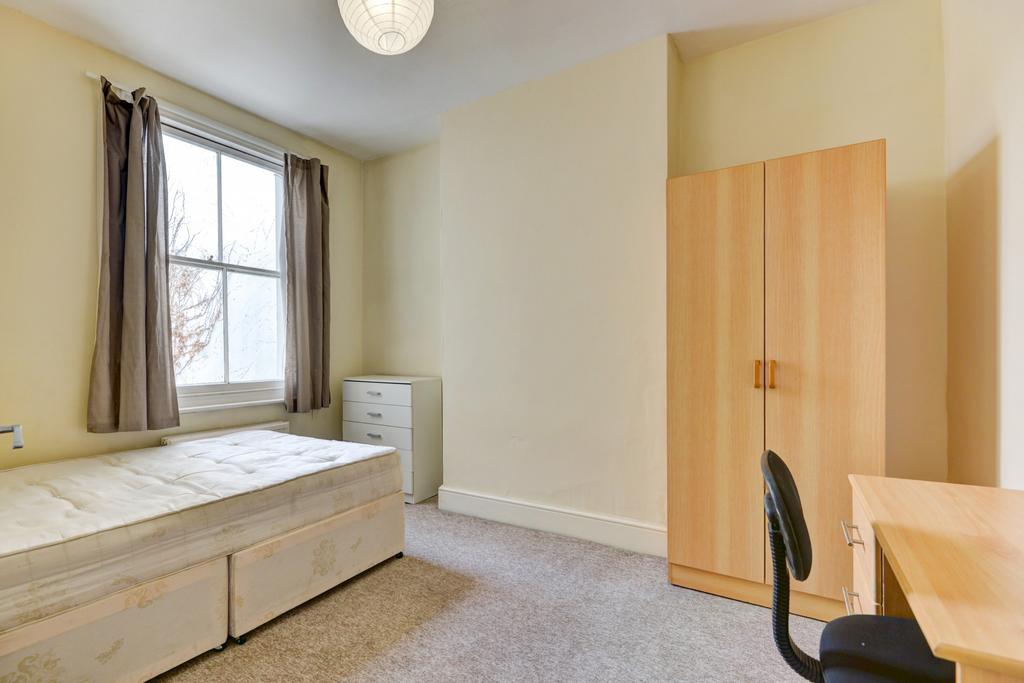 Bright and tidy bedroom featuring a large windo...