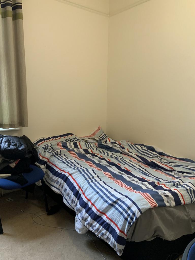 A cozy double bedroom featuring a neatly made b...