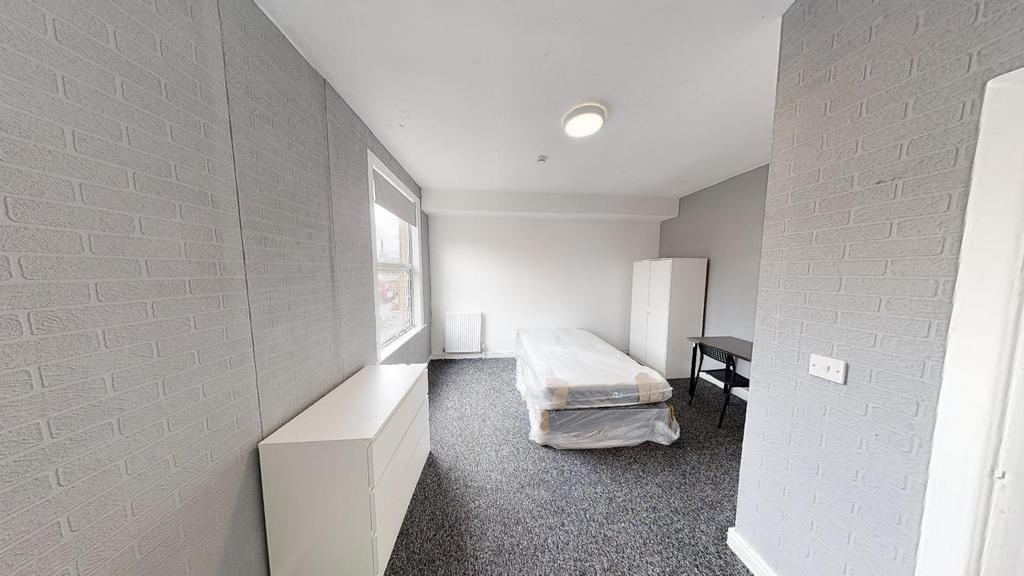 A bright and tidy bedroom with a large window p...