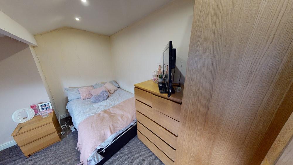 A cozy bedroom featuring a neatly made double b...