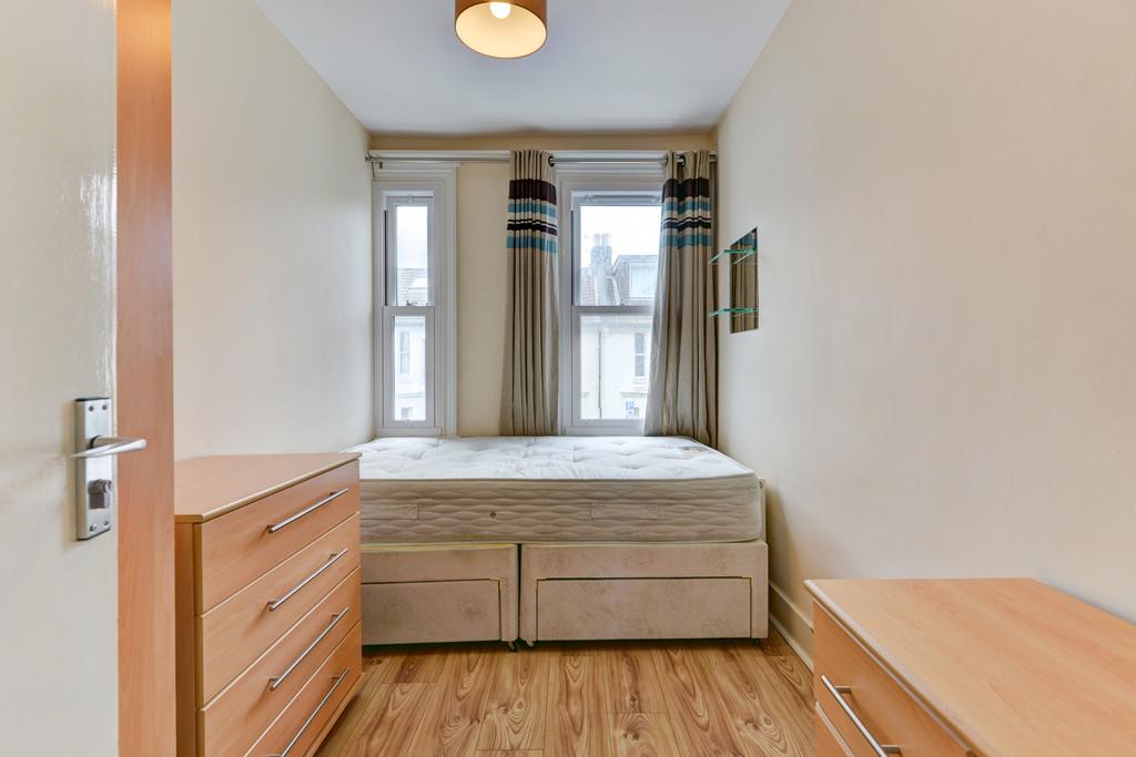 A well-lit, tidy single bedroom featuring a com...