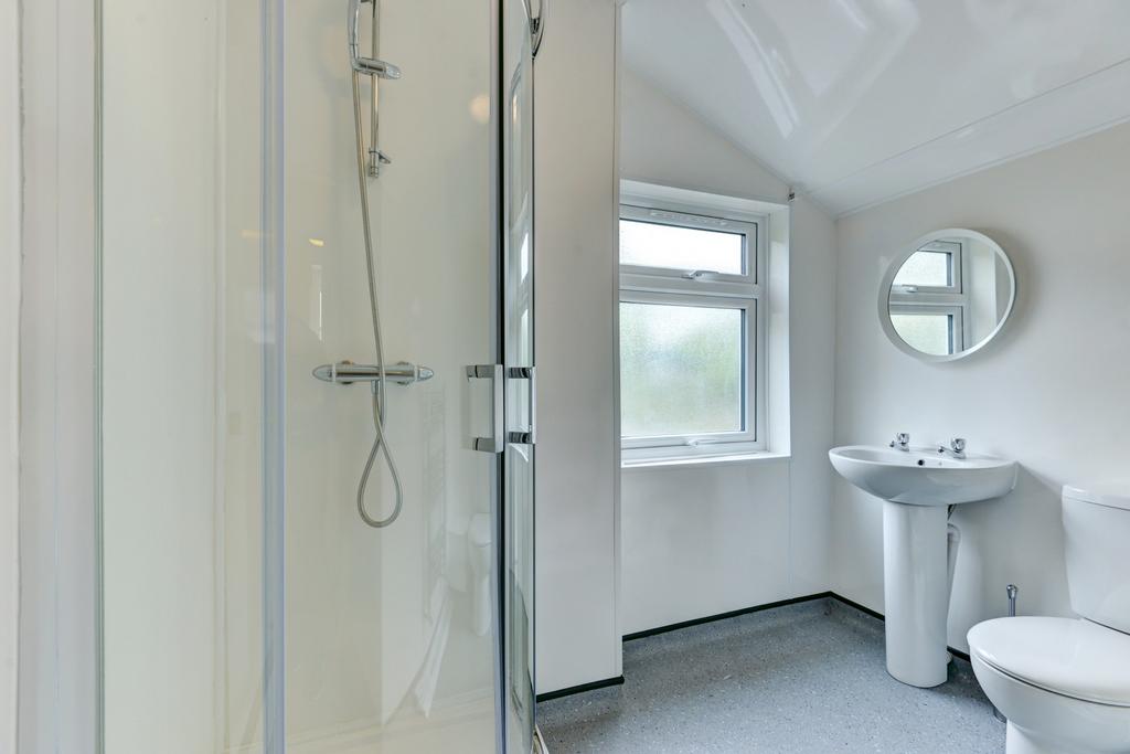 A clean and bright bathroom featuring a shower,...