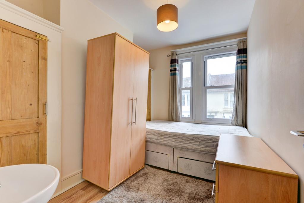 A cozy single bedroom featuring a comfortable b...