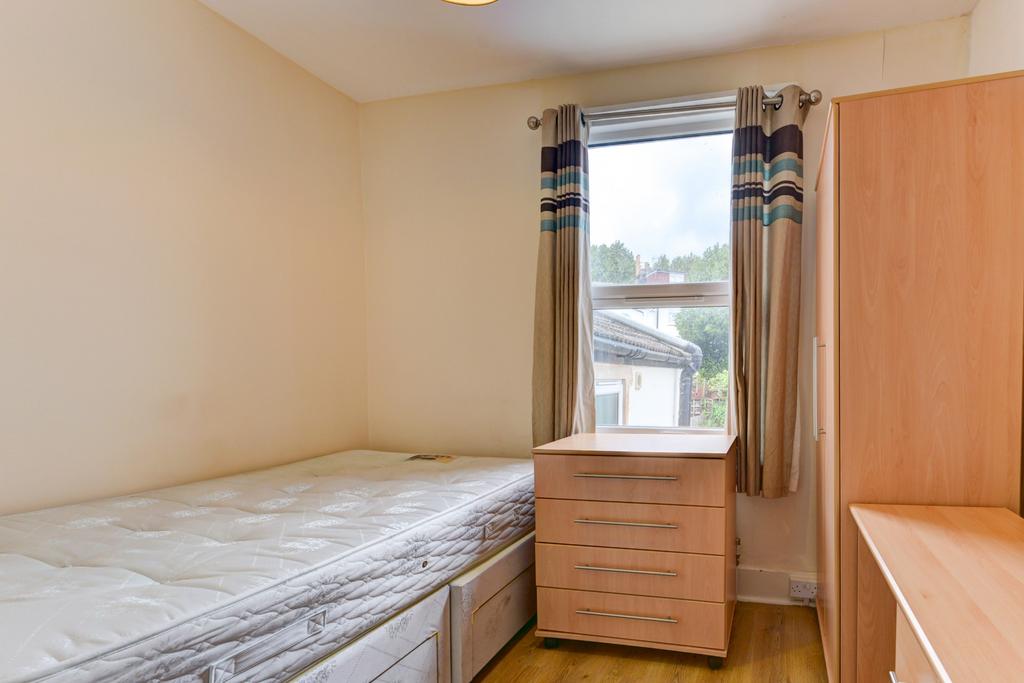 A cozy single bedroom featuring a single bed, a...