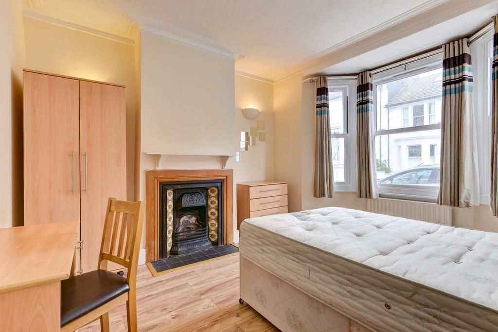 A bright and welcoming bedroom with a large win...