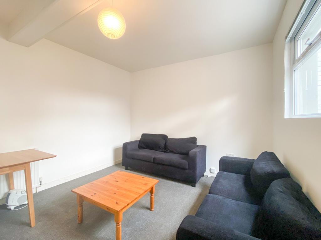 A bright and welcoming living room with two com...