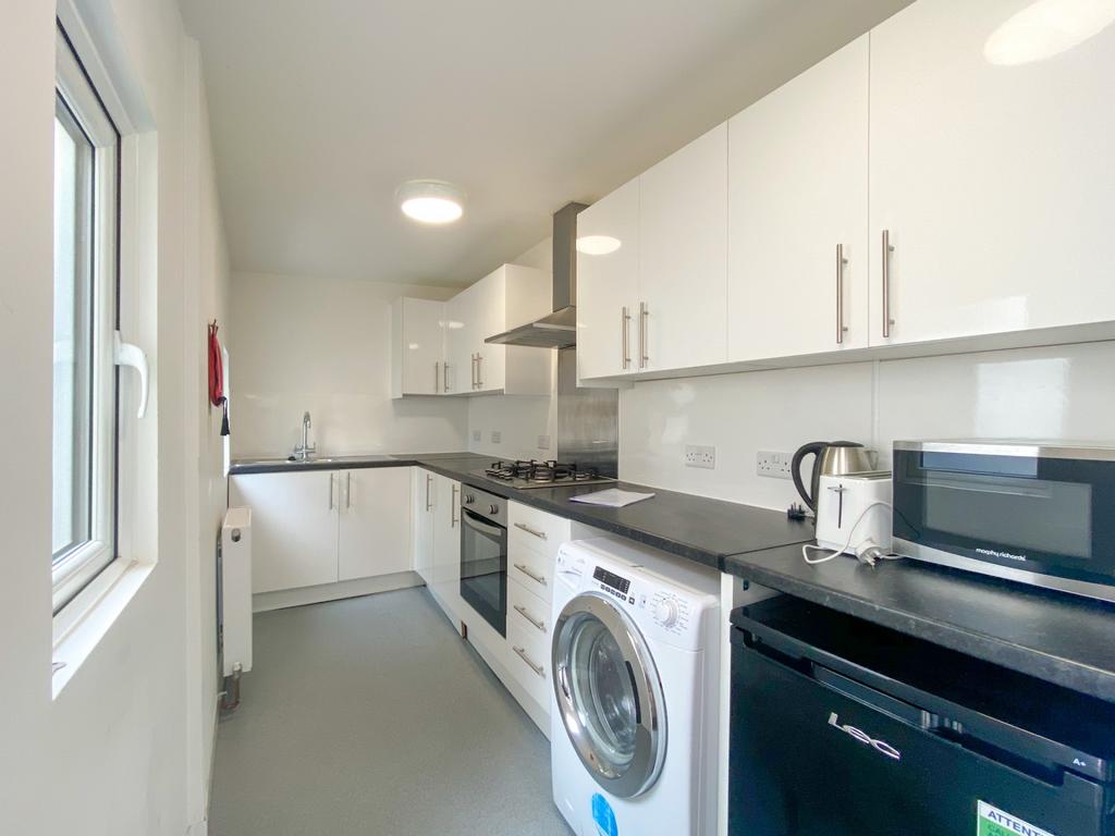 A bright, modern kitchen with white cabinets an...
