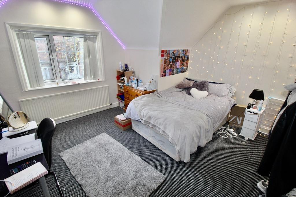 A clean and well-lit bedroom featuring a comfor...