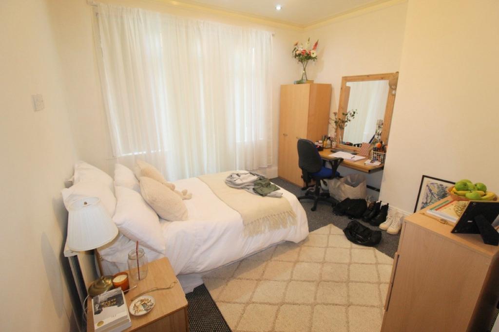 A cozy single bedroom featuring a neatly made b...