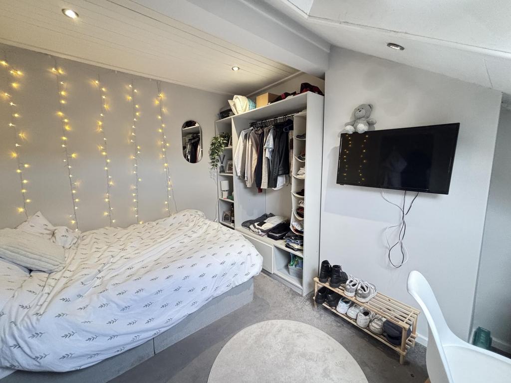 A bright and inviting bedroom featuring a comfo...