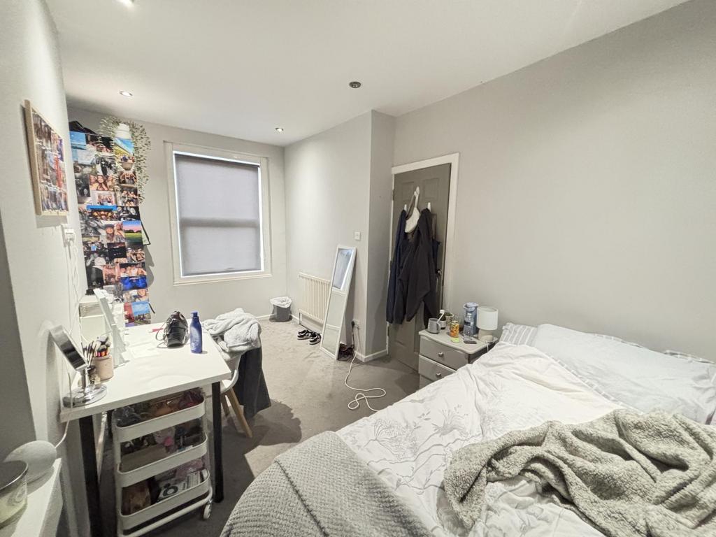 A bright and tidy bedroom featuring a comfortab...