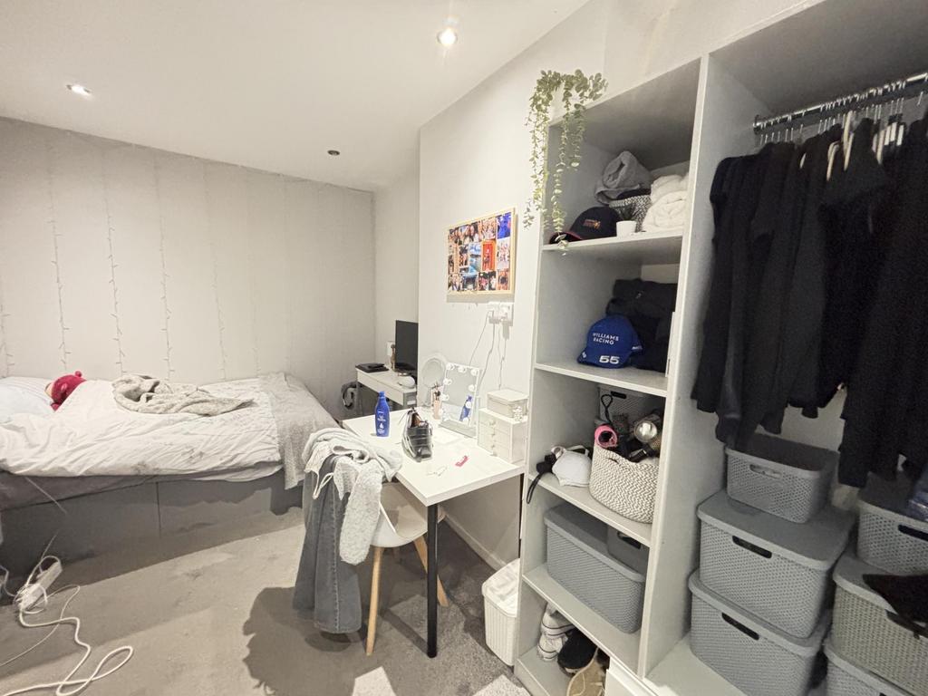 A bright and neatly maintained bedroom with a c...