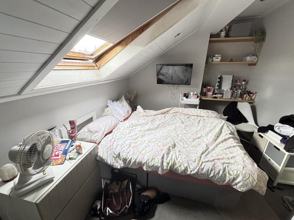 A spacious and bright bedroom featuring a large...